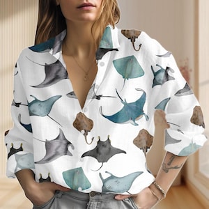 Puede incluir: Camisa blanca con botones con un estampado repetido de rayas de acuarela en tonos azules, grises y marrones. La camisa de manga larga tiene un cuello clásico y cierre de botones.