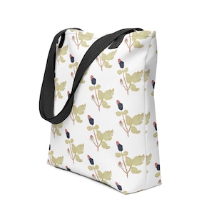 May include: White tote bag with a repeating pattern of watercolor-style blackberries and leaves. The leaves are a muted yellow-green, and the berries are black and red. The bag has black handles.