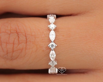 Puede incluir: Un anillo de banda de plata con una fila de diamantes de forma marquesa.