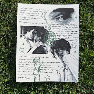 Puede incluir: Una obra de arte dibujada a mano sobre papel con bocetos de figuras, texto y motivos de estrellas. La obra de arte incluye un dibujo de dos personas besándose, un retrato de una persona y texto manuscrito. La obra de arte está sobre una superficie de hierba verde.