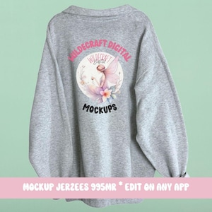 Puede incluir: Maqueta de sudadera gris con un diseño circular que presenta un hada con alas y flores. El texto "Wildcraft Digital" y "Mockups" está impreso en la sudadera.