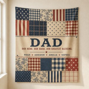 May include: A rectangular wall tapestry featuring a patchwork design of red, white, and blue patterns including stars, stripes, plaid, and floral motifs. The center displays the text DAD, OUR HERO. OUR GUIDE. OUR GREATEST BLESSING. and four names.