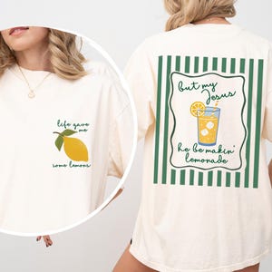 May include: Ivory-colored t-shirt with a lemon graphic and the text "life gave me some lemons" on the front. The back features a lemonade graphic with the text "But my Jesus he be makin' lemonade."