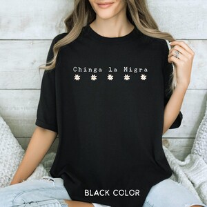 May include: Black t-shirt with the text "Chinga la Migra" and four white daisy graphics. The words "BLACK COLOR" are printed at the bottom of the shirt.