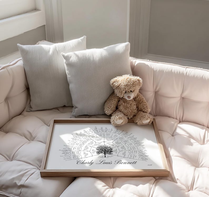Peut inclure: Impression d'arbre g&eacute;n&eacute;alogique encadr&eacute;e avec le nom "Charly Louis Bennett" en bas. L'impression est sur fond blanc avec un motif d'arbre et du texte. Un ours en peluche et deux coussins clairs reposent sur un canap&eacute; clair.
