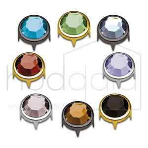 May include: Assortment of ten round, faceted, decorative, self-adhesive rhinestones with gold, silver, and black settings. Each rhinestone has a different color: light blue, green, dark blue, red, purple, light pink, brown, and orange.