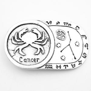 以下が含まれることがあります： カニの細かな画像と「Cancer」という文字が刻まれたシルバーチャーム。チャームには、かに座の星座とシンボルも描かれています。
