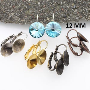 May include: Three pairs of earring findings with different finishes: gold, silver, and antique bronze. Each pair features a 12 mm round bezel setting.