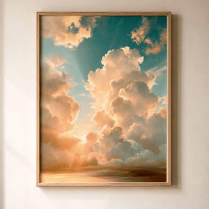 Puede incluir: Una pieza de arte mural rectangular vertical que presenta una impresión enmarcada de un cielo al atardecer con grandes y voluminosas nubes cúmulos. La escena muestra un degradado de luz naranja dorada que ilumina las nubes sobre un cielo azul verdoso.