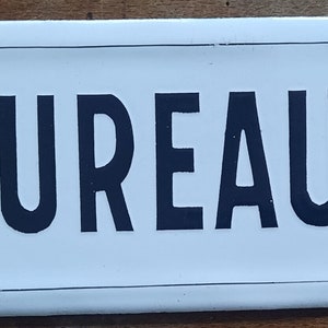 May include: White enamel sign with black lettering that reads "BUREAUX".
