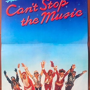 Puede incluir: Un cartel de película vintage de "Can't Stop the Music" con Village People. El cartel tiene un fondo azul con el título en letras rojas y blancas. El elenco se muestra con los brazos levantados.