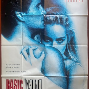 Może przedstawiać: Plakat filmowy do "Basic Instinct" z Michaelem Douglasem i Sharon Stone. Plakat jest w przeważającej mierze niebieski, przedstawiający twarze aktorów i dłoń. Tekst zawiera tytuł filmu i napisy.