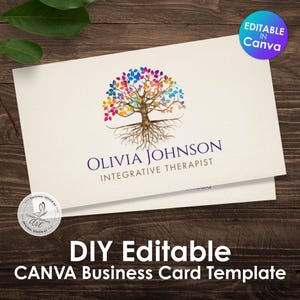 Może przedstawiać: Kremowy szablon wizytówki z logo drzewa z kolorowymi liśćmi. Karta zawiera imię i nazwisko "Olivia Johnson, Integrative Therapist". Tekst na dole brzmi "DIY Editable CANVA Business Card Template."
