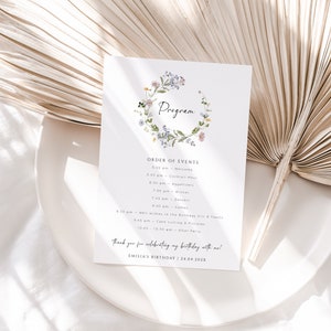 Könnte beinhalten: Ein Blumenkranz auf weißem Hintergrund mit dem Text "Program" in der Mitte. Der Text "Order of Events" befindet sich unter dem Kranz, gefolgt von einer Liste von Veranstaltungen mit Uhrzeiten. Der Text "Thank you for celebrating my birthday with me!" befindet sich unten auf der Seite, mit dem Text "Emilia's Birthday | 24.04.202X" darunter.