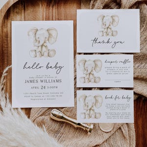 Może przedstawiać: Zaproszenie na baby shower z uroczym obrazkiem słonia. Zaproszenie zawiera tekst "hello baby", imię "James Williams", datę "April 24", godzinę "3:00PM", adres "1234 Peach Tree Road, Sonoma AD", informacje RSVP "RSVP to James at 123-456-78-90" oraz informacje o rejestrze "Registered at Amazon".