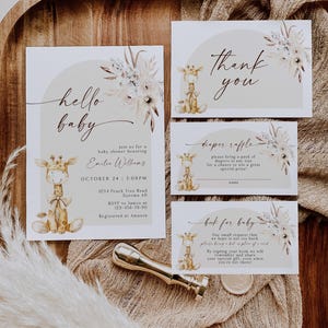 Puede incluir: Un conjunto de tres tarjetas para baby shower con una ilustración de jirafa y detalles florales. Las tarjetas están impresas en cartulina blanca con un fondo marrón claro. El texto en las tarjetas dice "hello baby", "thank you", "diaper raffle" y "book for baby".