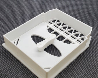 Könnte beinhalten: Weiße Plastikform mit rechteckiger Form und einem erhabenen Design in der Mitte. Die Form hat ein Gittermuster an den Seiten und ein kleines, erhabenes, rechteckiges Stück in der Mitte.