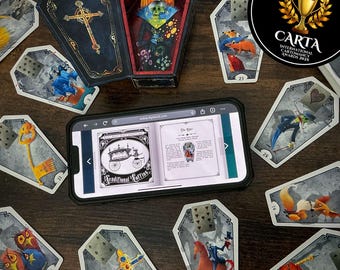 May include: An assortment of coffin-shaped tarot cards with various illustrations, including a key, a cross, and a rider on a horse. A coffin-shaped box is open, revealing a skull. A smartphone displays a book page. The image includes the text "CARTA INTERNATIONAL CARTOMANCY AWARDS 2025."