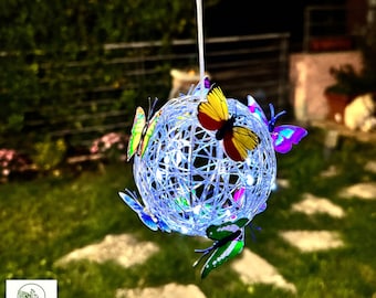 May include: A blue string ball with a white light string inside and colorful butterfly decorations hanging from it.