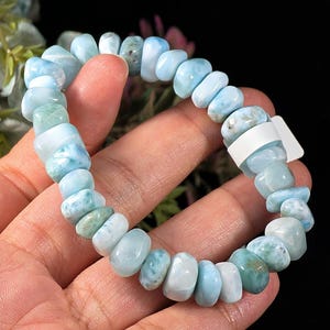 Puede incluir: Una pulsera el&aacute;stica compuesta por numerosas cuentas de Larimar pulidas y rodadas en tonos variados de azul cielo, turquesa y blanco. Las cuentas son redondeadas e irregulares, ensartadas en un cord&oacute;n el&aacute;stico y cuentan con una peque&ntilde;a etiqueta blanca.