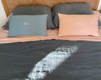 Duo of “you and me” linen cushions. Set of 2 embroidered linen cushions. The blue is embroidered with the word "you" and the pink with the word "me".