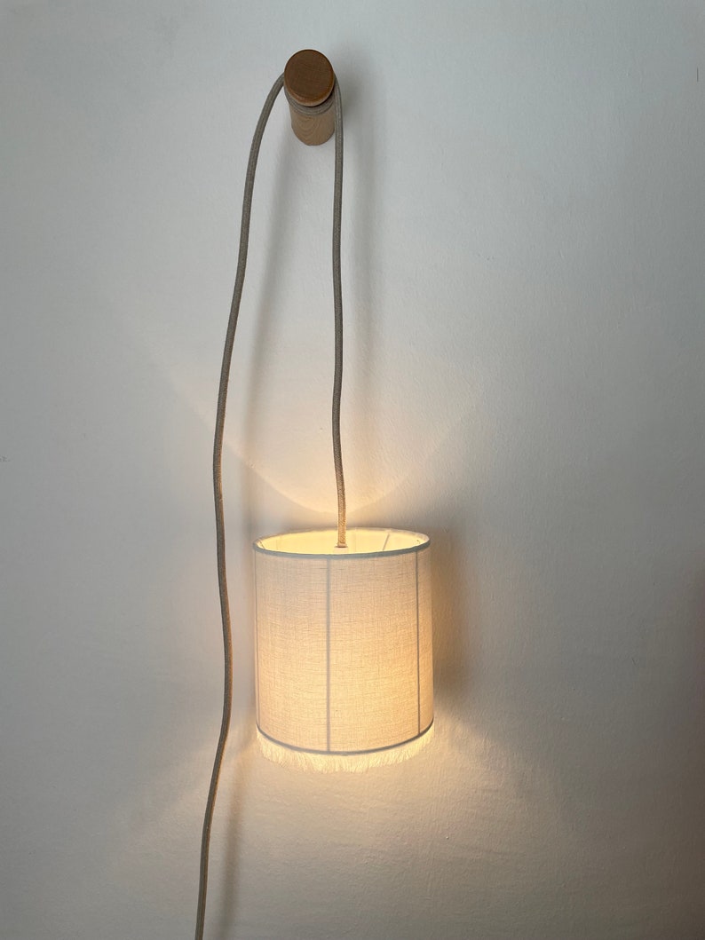 Lampe baladeuse en lin ivoire. La délicatesse du lin lavé se retrouve sur ces lampes baladeuses soulignées de fines franges au style rétro. image 2