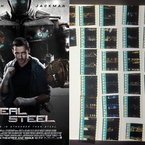 Pode incluir: Cartaz do filme "Real Steel" com Hugh Jackman e um robô. O cartaz é escuro com o título em prata. À direita, negativos de filme dispostos em filas. O slogan do filme também é visível.