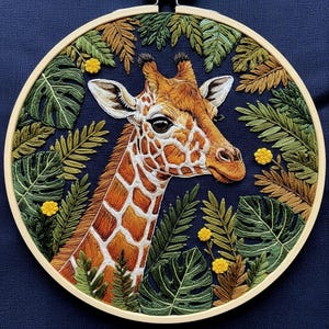 May include: Embroidered giraffe head and neck, featuring a detailed pattern of orange and white spots, set against a dark blue background. The giraffe is surrounded by green and brown embroidered foliage and yellow flowers, all within a wooden hoop.