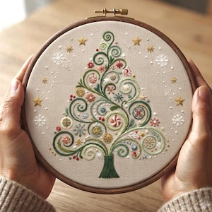 Peut inclure: Un tambour à broder contenant un panneau de tissu beige avec un motif de sapin de Noël brodé. L'arbre présente des branches vertes en spirale, des ornements circulaires colorés et de petites baies rouges. Des flocons blancs et des étoiles dorées entourent l'arbre.