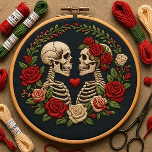 May include: An embroidered hoop art piece featuring two skeletal figures facing each other, surrounded by red and cream-colored roses and green foliage. A red heart is between the skulls. Embroidery floss and scissors are also visible.