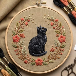 May include: A detailed embroidery hoop featuring a black cat gazing upwards, surrounded by a floral wreath of red flowers and green leaves. The background is a tan fabric. Embroidery floss in various colors is visible.