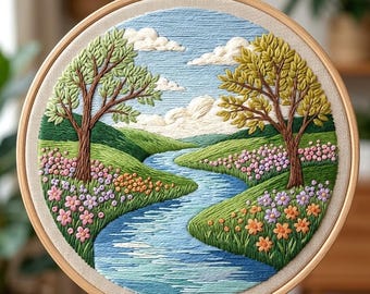 Könnte beinhalten: Gestickte Landschaftskunst in einem Holzreifen. Die Szene zeigt einen Fluss, der sich durch grüne Hügel schlängelt, mit Bäumen und bunten Blumen an den Ufern. Der Himmel ist blau mit flauschigen weißen Wolken. Die Stickerei ist detailliert und strukturiert.