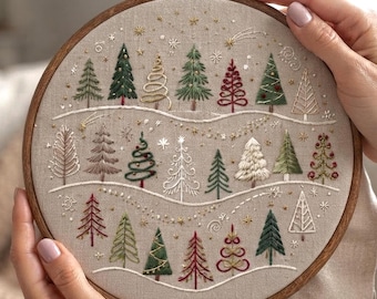 May include: A circular wooden embroidery hoop containing a beige fabric panel with hand-stitched designs of various evergreen trees in shades of green, red, white, and gold. The trees are arranged in three horizontal rows separated by wavy lines.