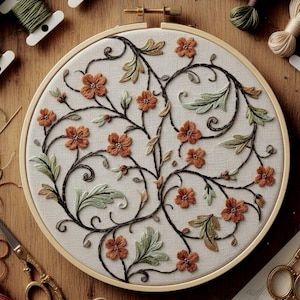 May include: A round embroidery hoop featuring a floral design. The design includes orange flowers, green leaves, and dark brown stems, all stitched on a cream-colored fabric. The hoop is made of light-colored wood, and the background shows spools of thread and scissors.