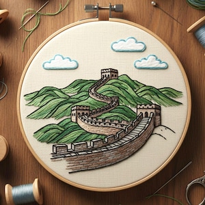 May include: An embroidery hoop featuring a detailed hand-stitched depiction of the Great Wall of China. The artwork showcases the wall winding through green hills under a blue sky with fluffy white clouds. The hoop is set against a wooden surface with sewing supplies.