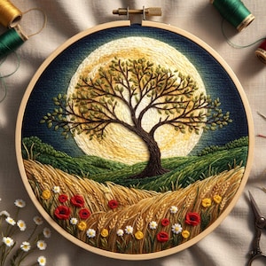 Op de afbeelding: Handgemaakte borduurring met een boom silhouet tegen een volle maan. De scène bevat tarwe, wilde bloemen en glooiende heuvels, allemaal weergegeven in levendige draadkleuren. De houten ring is zichtbaar en het kunstwerk roept een serene, natuurlijke landschap op.