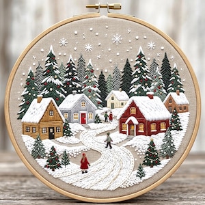 Pode incluir: Um bastidor de bordado circular contendo uma cena de vila de inverno costurada à mão em tecido bege. O design apresenta casas cobertas de neve em vermelho, amarelo e cinza, árvores perenes com pequenos enfeites vermelhos e figuras num caminho.