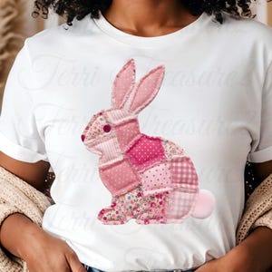 May include: White t-shirt featuring a patchwork pink bunny design. The bunny is composed of various pink fabrics with floral, polka dot, and gingham patterns. The text "Terri Treasure" is visible on the shirt.