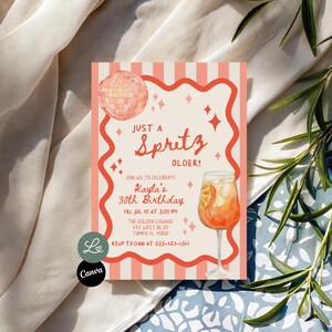 Op de afbeelding: Een rechthoekige verjaardagsuitnodiging met crème en koraalkleurige strepen, een golvende koraalkleurige rand, een discobal en een spritz cocktail. De tekst luidt: Just a Spritz Older! Join us to celebrate Kayla's 30th Birthday, Fri, Jul 10 at 5:00 PM, The Golden Lounge, 475 West Blvd, Tampa, FL 10800, RSVP to Dani at 555-123-4567.