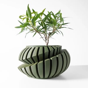 May include: A green, geometric planter with a unique, swirling design. A small green plant with leaves is growing in the planter.