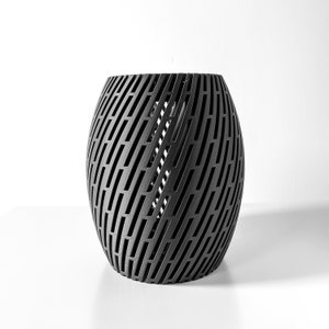 May include: A black, cylindrical, decorative lampshade with a geometric pattern of intersecting lines.