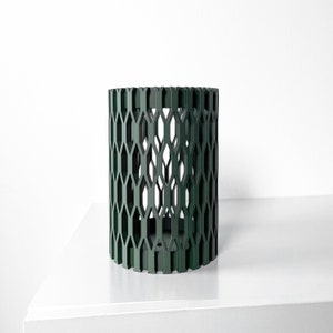 May include: A dark green cylindrical planter with a geometric pattern. The planter is made of a lightweight material and has a hollow center.