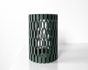 May include: A dark green cylindrical planter with a geometric pattern. The planter is made of a lightweight material and has a hollow center.