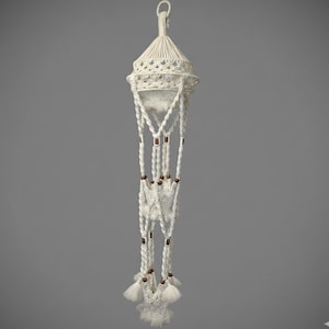 May include: A cream-colored macrame plant hanger featuring a tiered design with three sections. The structure is composed of knotted cotton cord, accented with small brown wooden beads at each junction, and finished with decorative tassels at the bottom.