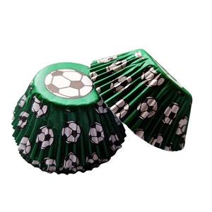 May include: Green cupcake cases with a white football pattern.