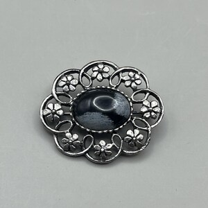 Vintage silver tone oval shaped floral cut out brooch with black and grey central cabochon stone - gift for her
