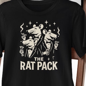May include: Black t-shirt featuring a graphic of three cartoon rats in tuxedos, smoking and holding drinks, with the text "THE RAT PACK" in a bold, white font. The shirt is hanging on a black hanger.