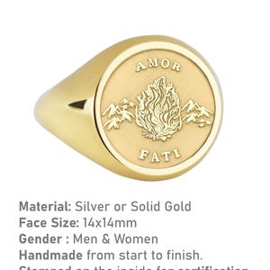 K&ouml;nnte beinhalten: Ein goldener Siegelring mit einer runden Fl&auml;che, die ein stilisiertes Flammenmotiv und die Worte "AMOR FATI" in einer Serifenschrift zeigt.