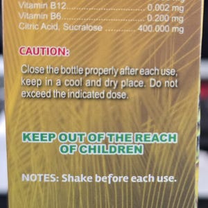 May include: A product label with text including "EXTRA STRENGTH" and a list of ingredients per 60ml (2oz) serving. The label also includes a caution, notes, and the product's origin in Miami, FL, USA, with a "MADE IN USA" label.