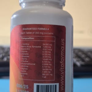 Pu&ograve; includere: Una bottiglia di integratore bianca con un'etichetta rossa e arancione. L'etichetta elenca ingredienti come L-Carnitina e Vitamina B6. La bottiglia ha un tappo bianco e il testo "VIT FARMA" &egrave; visibile. La bottiglia contiene 360 mg di integratori.